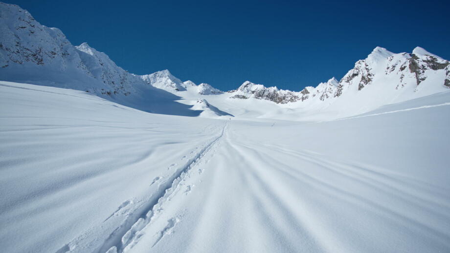 Skitourenspur im Schnee bei bestem Wetter