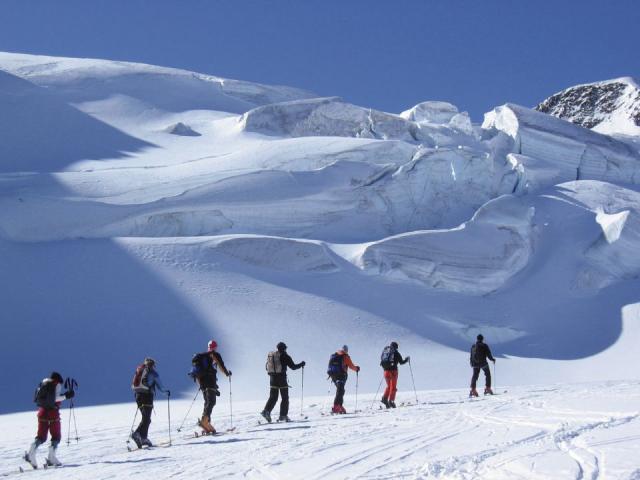 Skitourengruppe in einer Reihe im Schnee