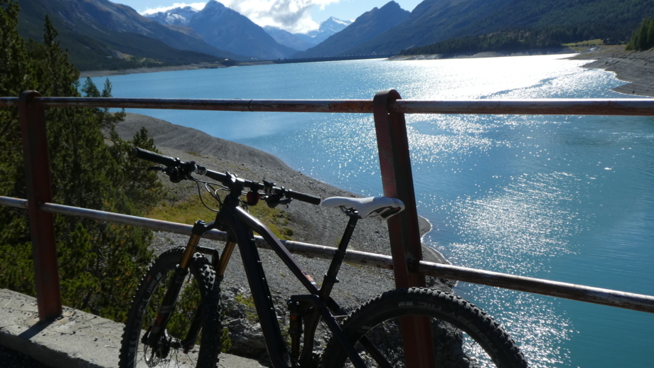 Ein Mountainbike stehend mit Seeblick und der Bergwelt im Hintergrund.