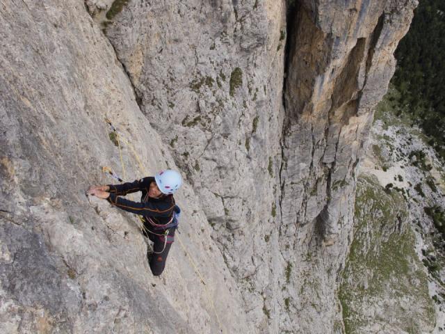 Frau klettert an einer Felswand