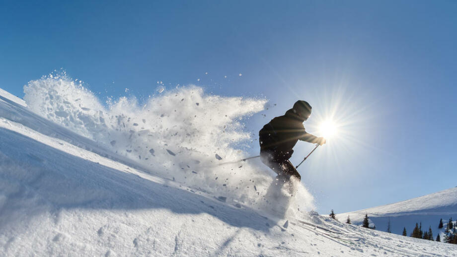 Skifahrer bei der Abfahrt im Tiefschnee