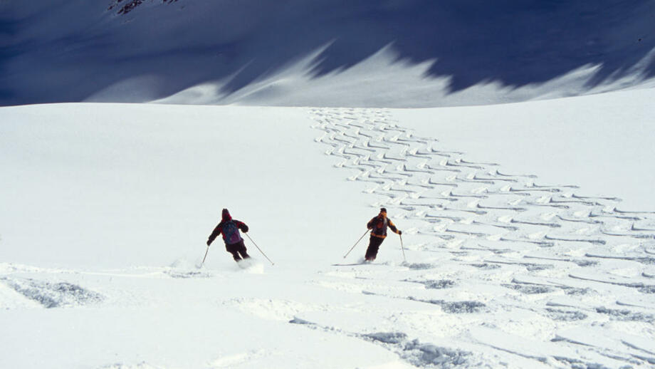 Skifahrer fahren die eine Tiefschnee Abfahrt herunter