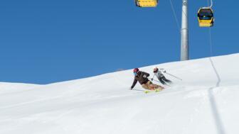 Skifahrer fahren unter dem Lift ab