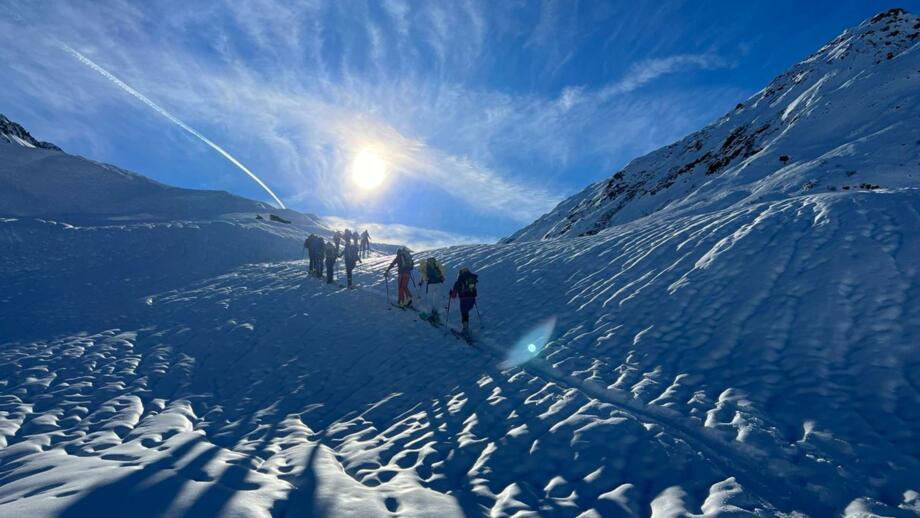 Drei Gruppen á drei Skitourengehern im Aufstieg rund zu einem der Gipfel rund um die Hütte