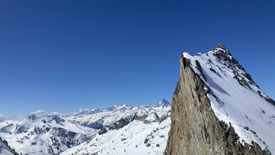 Felsvorsprung mit verschneiten Gipfeln im Hintergrund