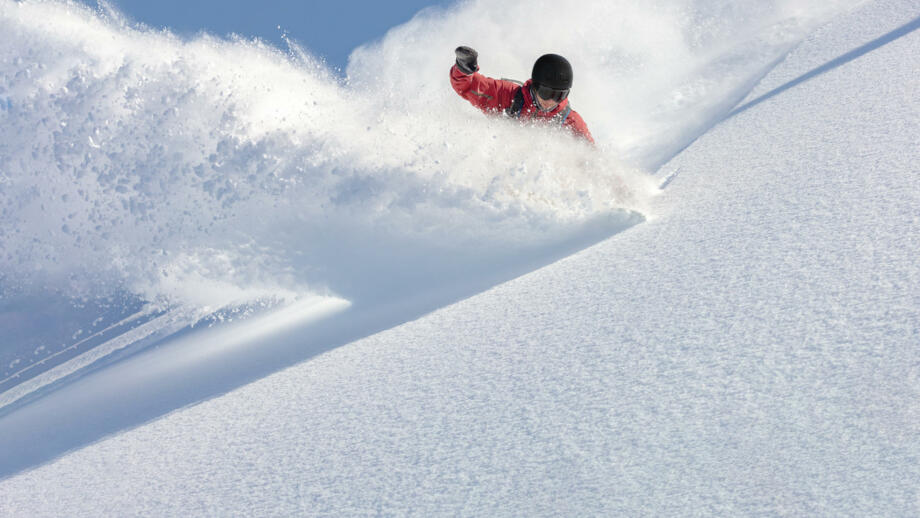 shutterstock-1647210289-snowboard-winter-powder-pulver-schnee-sonne-board-abfahrt.jpg