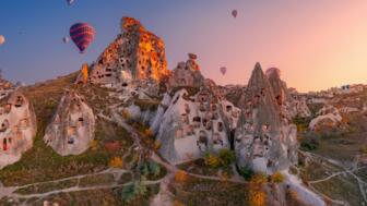 tuerkei-kappadokien-tukap-antike-stadt-des-schlosses-uchisar-mit-heissluftballons-bei-sonnenuntergang-goereme-shutterstock_2260055961.jpg