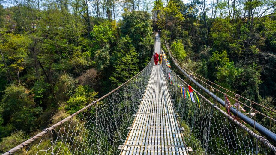 nepla-hikat-trekking-enthusiasten-ueberqueren-eine-haengebruecke-auf-balthali-village-trek-kathmandu-valley-shutterstock_2444372853.jpg