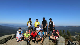 Eine Mountainbikegruppe am Gipfel im Bayerischen Wald.