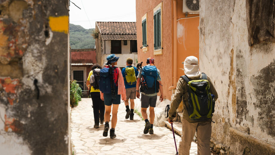 Wanderer in einer Dorfgasse auf Korfu