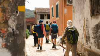 Wanderer in einer Dorfgasse auf Korfu