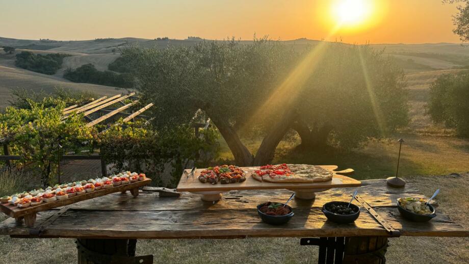 Ein Tisch mit dem Abendessen am der Toskana bei Sonnenuntergang