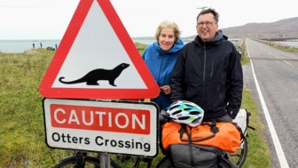 Ein Warnschild mit zwei Fahrradfahrer während des Crossbike Erlebnis auf dem Hebriden Weg in Schottland.