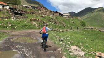 Ein Mountainbiker unterwegs auf Tour durch den kleinen und großen Kaukasus bei Sonnenschein.