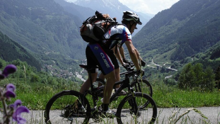 Eine MTB Gruppe unterwegs auf der Tour durch die Bilderbuch Schweiz mit den grandiosen Bergwelt im Hintergrund.