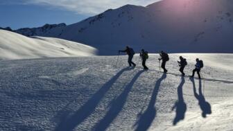 Schneeschuhgruppe mit Sonne im Hintergrund