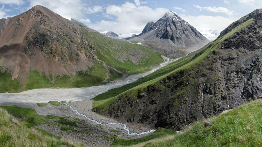 Gletscherfluss, grüne Häunge, Felsgipfel im Tienshan