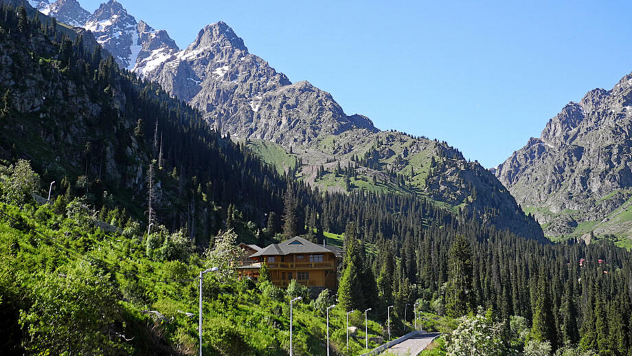 Tuyuk-Schlucht im Tienshan mit Straße, Haus, Wald und felsigen Bergen