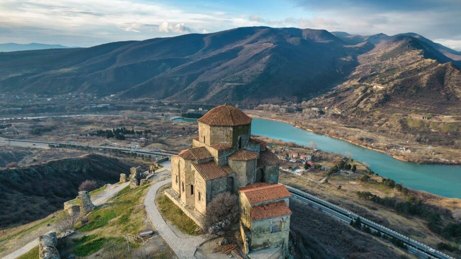 Kloster Jvari iin Georgien mit Sicht auf Fluss und braunes Hütelland