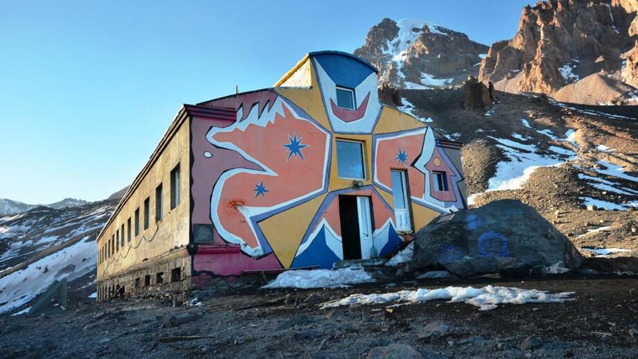 Bunt bemalte Bethlemi-Hütte am Fünftausener Kasbek in Georgien mit Felsen, Schotter und Schneeresten
