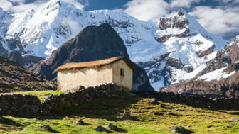 Bauerngehöft mit steinmauern vor Gletscer in der Cordillera Vilcanota