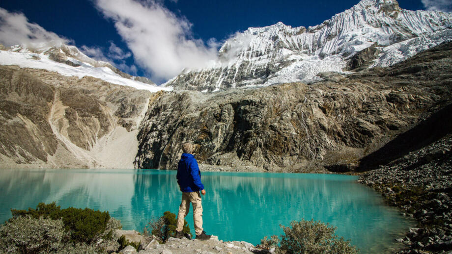 Wanderer an einem Bergssee vor mächtigen Hängegletschern