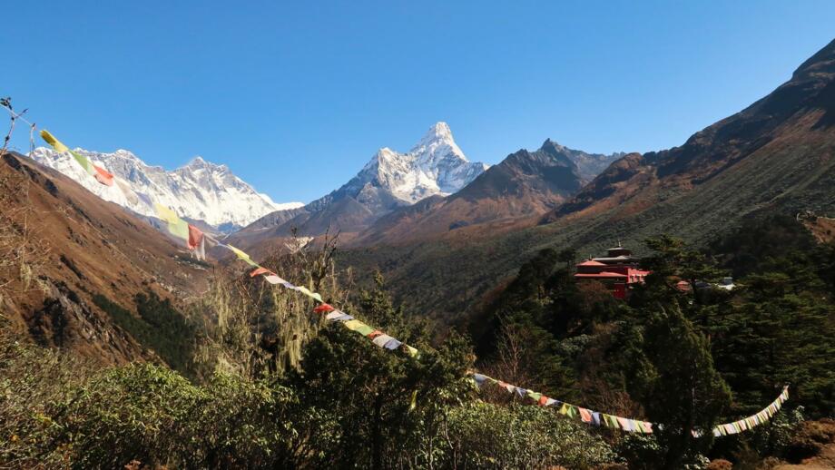 nepal-hikte-blick-auf-das-kloster-des-tengboche-dorfes-mit-einer-gebetsfahne-im-vordergrund-und-den-gipfeln-von-everest-lhotse-und-ama-dablam-im-hintergrund-shutterstock_2486143989.jpg