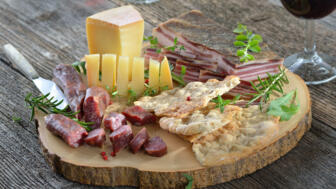 Ein Vesperbrettchen belegt mit Südtirolder Spezialitäten: Speck und Käse.