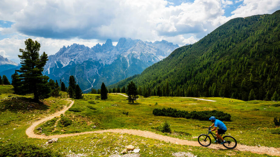 Ein Mountainbiker auf einem befestigen Weg unterwegs in Südtirol von der Plose zum Monte Grappa.