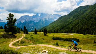 Ein Mountainbiker auf einem befestigen Weg unterwegs in Südtirol von der Plose zum Monte Grappa.