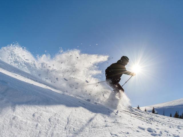 Skifahrer bei der Abfahrt bei besten Verhältnissen im Powder