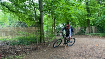 Eine Mountainbikerin während des MTB-Fahrtechniktrainings im Wald.