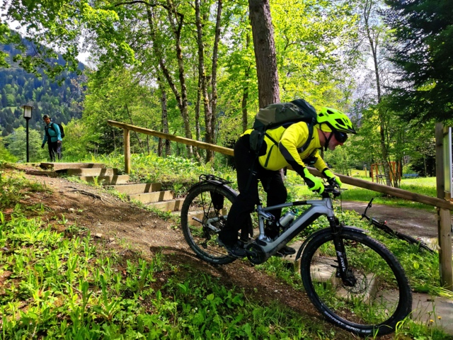 Ein E-Mountainbiker während der Abfahrt auf einem Trail während des MTB-Fahrtechniktrainings.