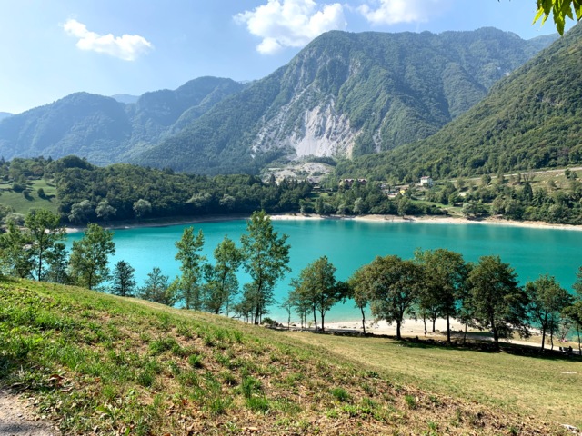 Ein türkisblauer See mit der umliegenden Bergwelt im Hintergrund.