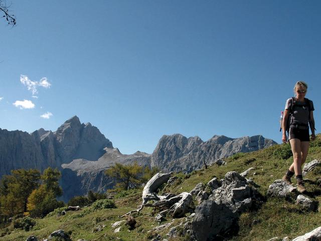 Wanderin im Vordergrund und Gipfel Triglav im Hintergrund