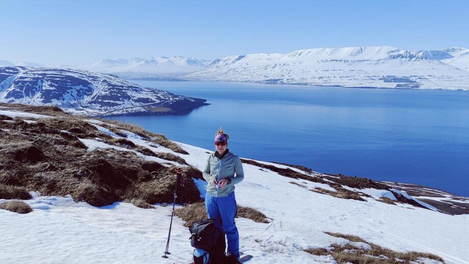 Blick von Hinten auf eine Frau, die den Fjord bestaunt