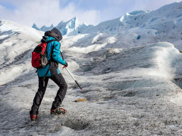 Person mit Steigeisen und Pickel auf einem Gletscher