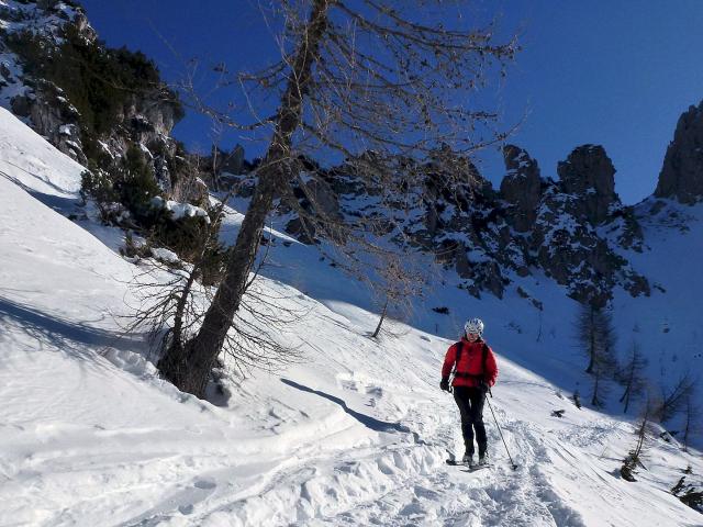 Skitourengeherin beim Aufstieg mit blauem Himmel
