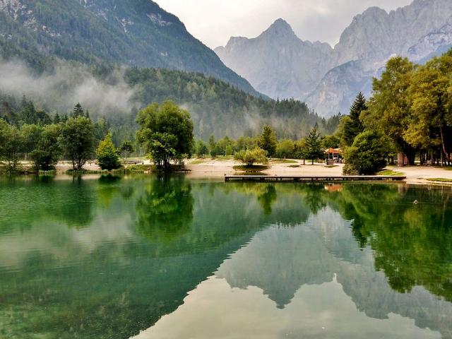 Bergsee mit Wald und Bergen im Hintergrund