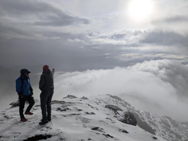 Zwei junge Männer blicken vom Gipfel des Pikey Peak in die Ferne
