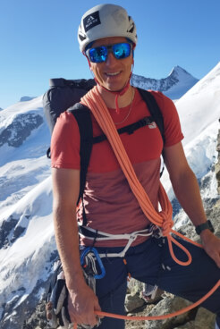 Bergführer Daniel Schröck lächelt uns mit Seil in der Hand ins Gesicht