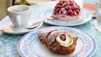 Ein Tisch mit frischen Nachspeisen, Croissan, Kuchen und ein Espresso