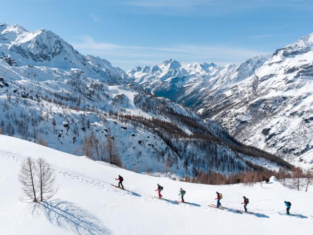 Skitouren Gruppe im Aufstieg im sonnenverwöhnten Tag