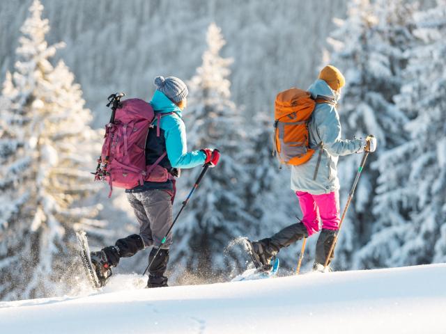 Zwei Schneeschuh-Geherinnen im tiefverschneiten Wald