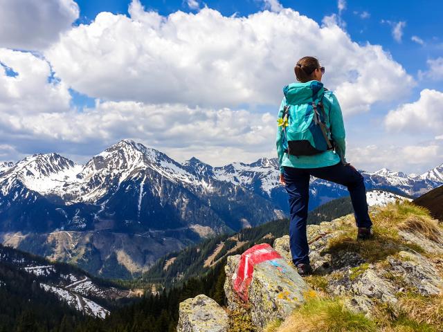 Wanderin auf Gipfel am Abhang mit Bergblick