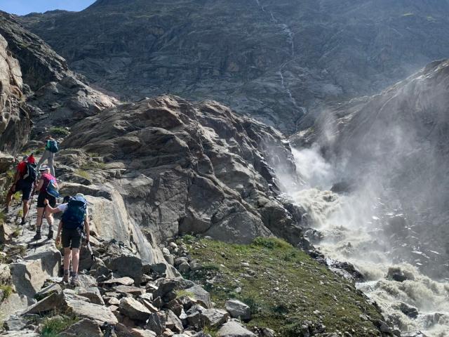 Wanderer vor einem Wasserfall in den Alpen
