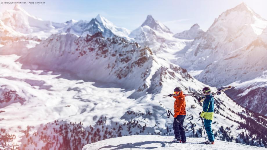 Zwei Skifahrer mit geschulterten Skiern