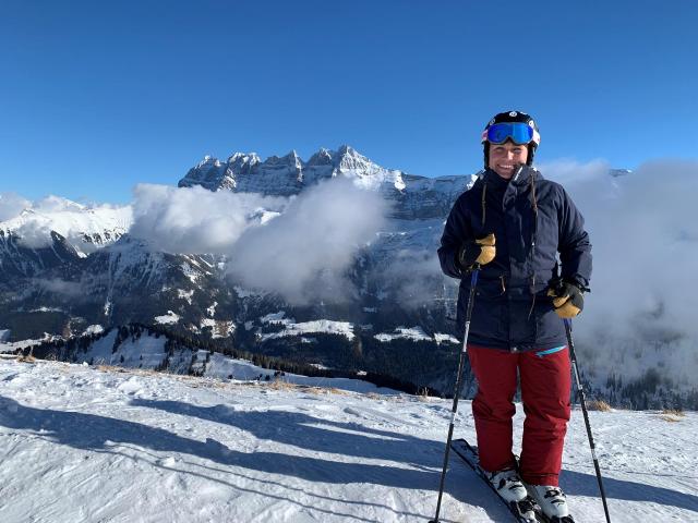 Skifahrerin auf Piste vor Bergpanorama