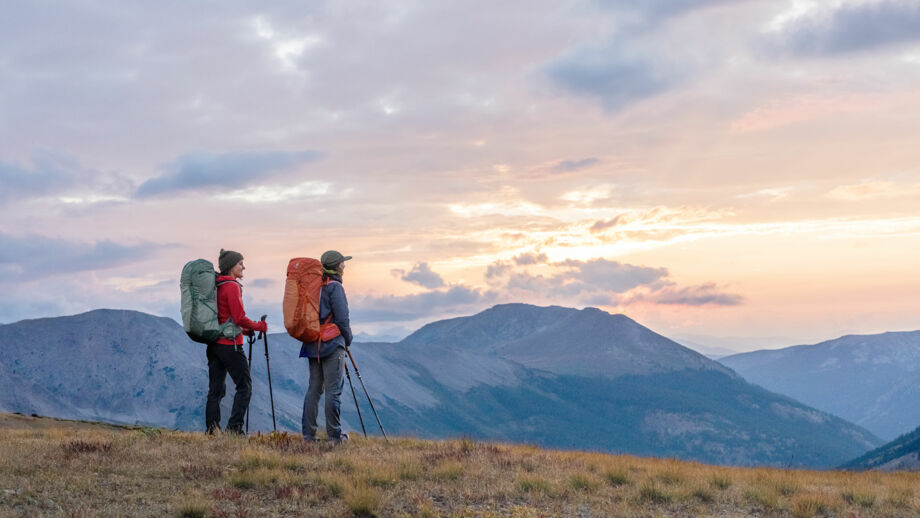 Zwei Personen mit Wanderrucksäcken genießen die Aussicht