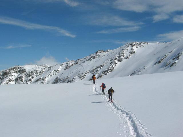 Schneeschuhgruppe unterwegs durch die weite verschneite Landschaft der Stubaier Alpen